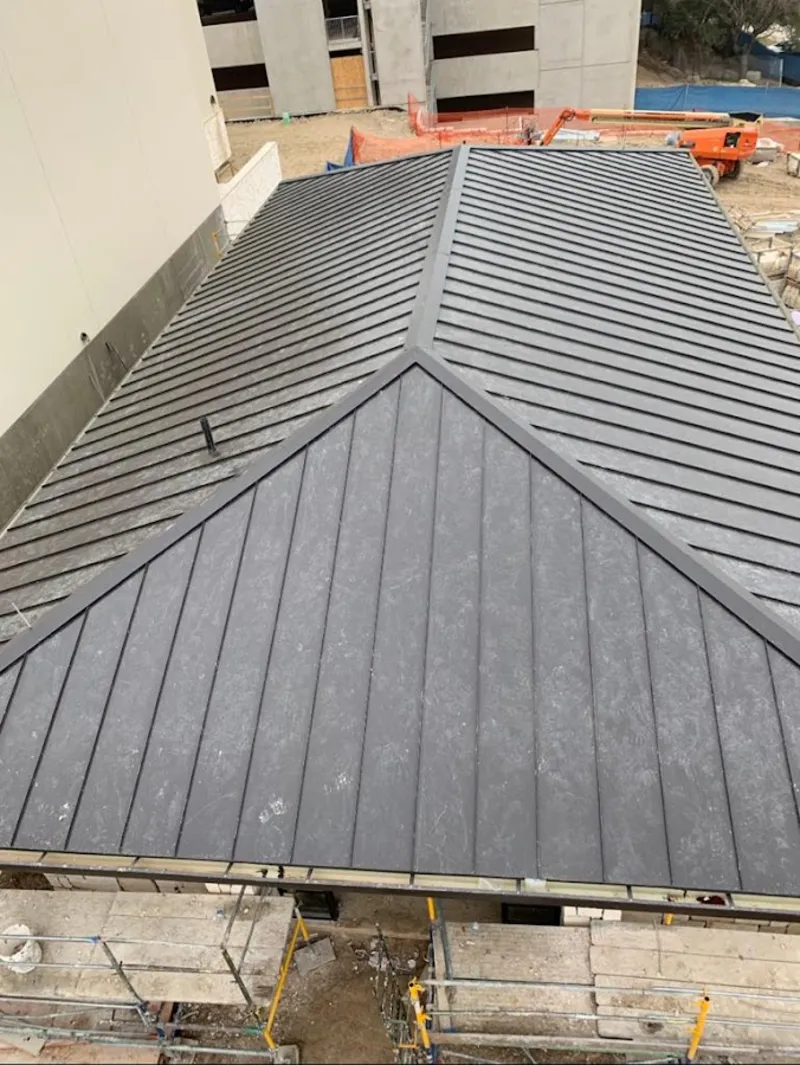 Commercial metal roof construction with crane equipment in West Samoset