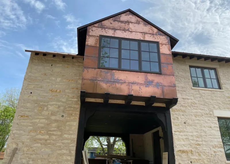 Copper metal panel facade on a stone building for Roof Repair in West Samoset